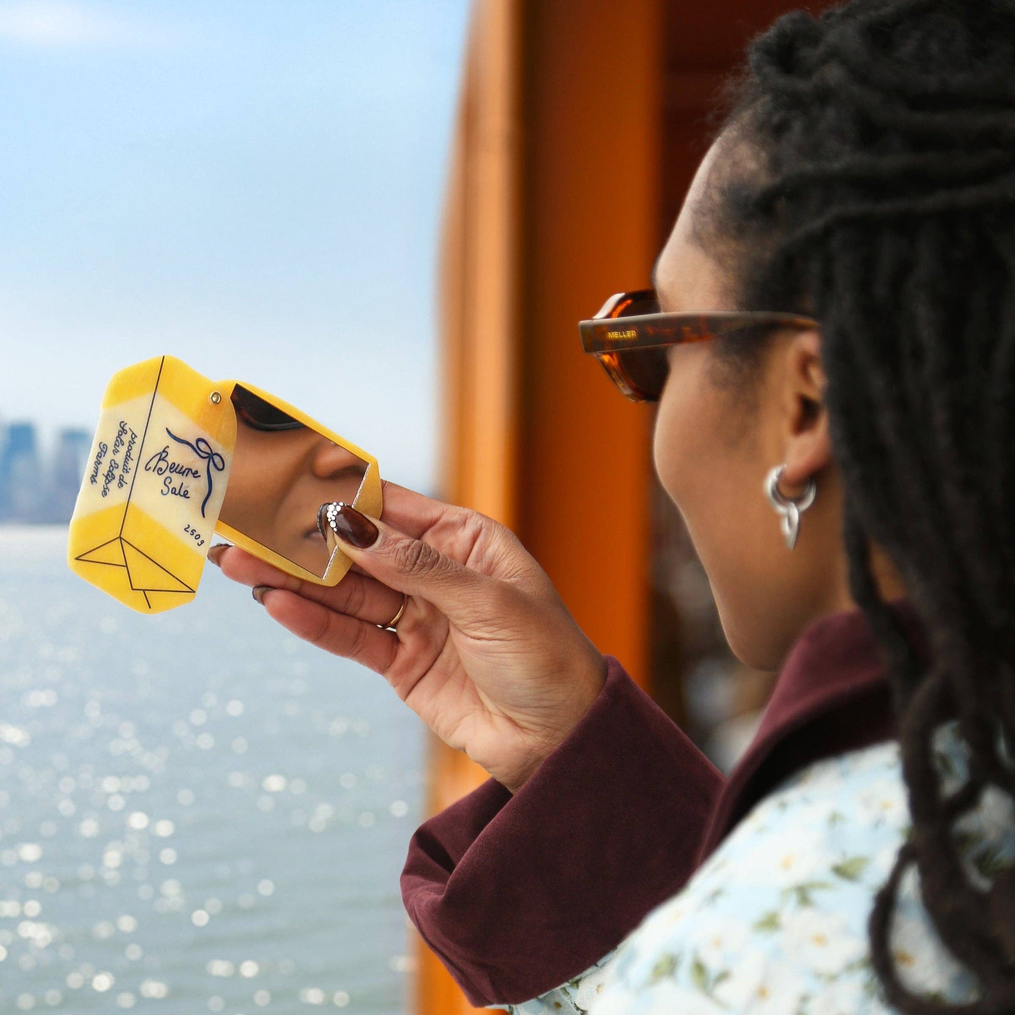 Person holding a yellow product with a cityscape in the background