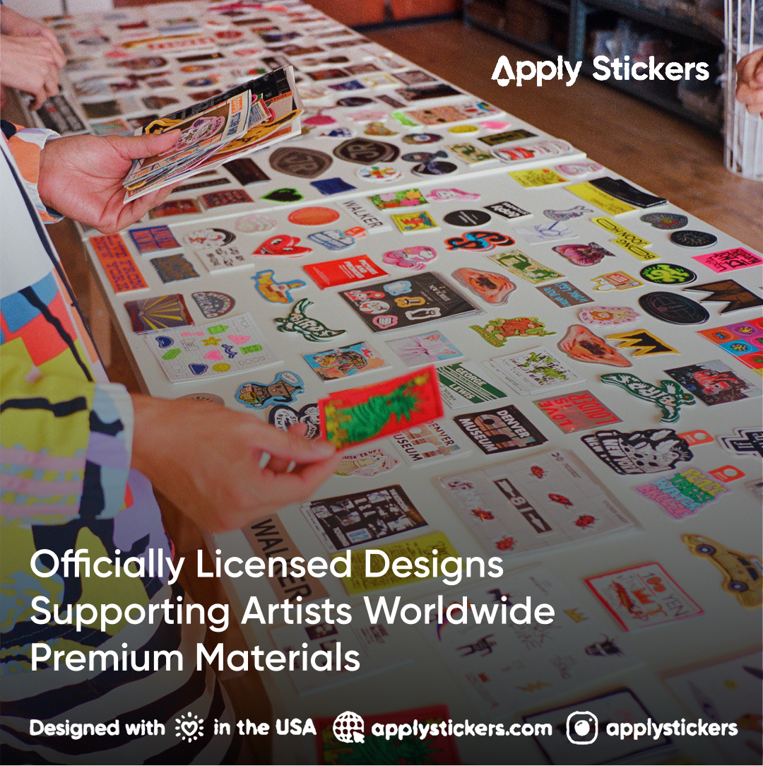 A person's hands holding and examining a sheet of colorful stickers laid out on a table, with more sheets visible in the background. Promotional text overlays mention 'Apply Stickers' and 'Officially Licensed Designs'.