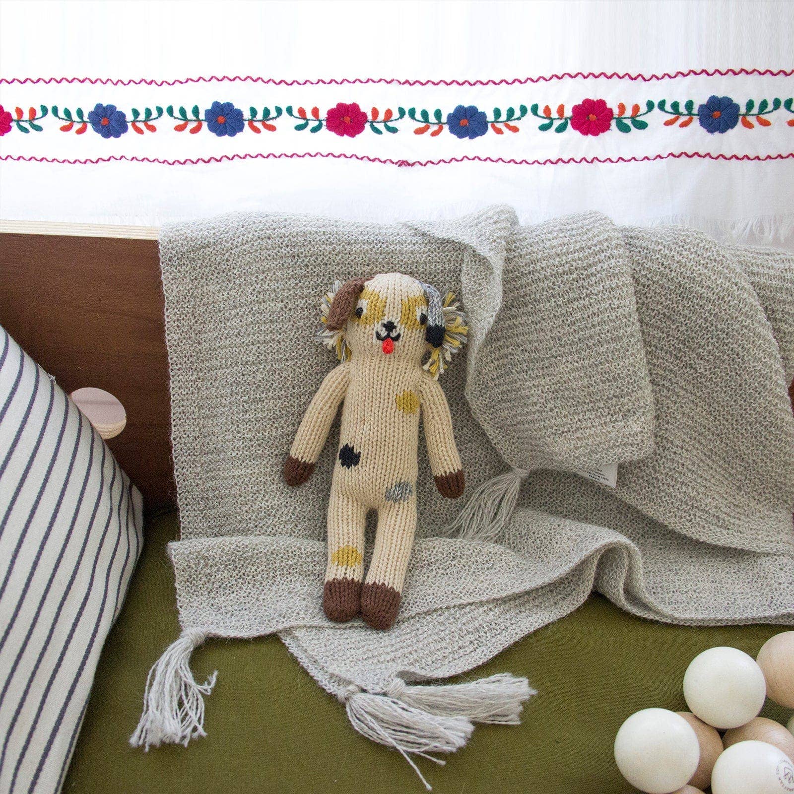 Knitted doll on a textured surface with decorative elements