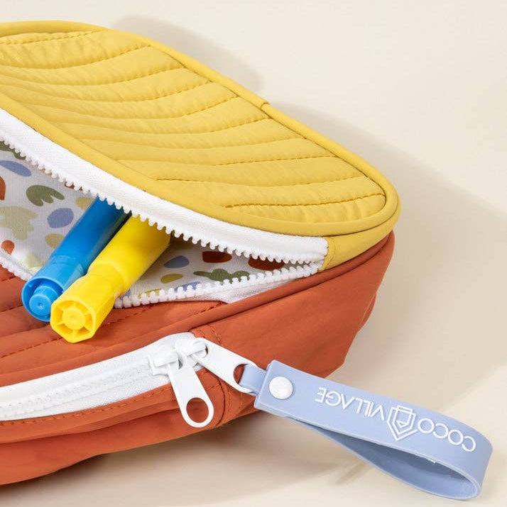 Colorful quilted pouch with a visible brand tag on a beige background