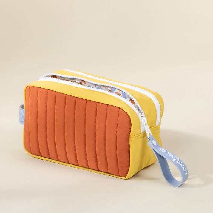 Quilted rectangular pouch with a yellow top and orange bottom on a beige background