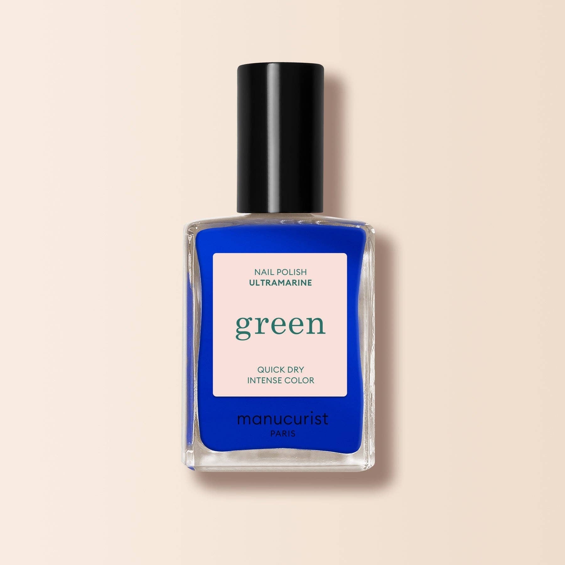 Nail polish bottle with blue color and 'green' text on a beige background