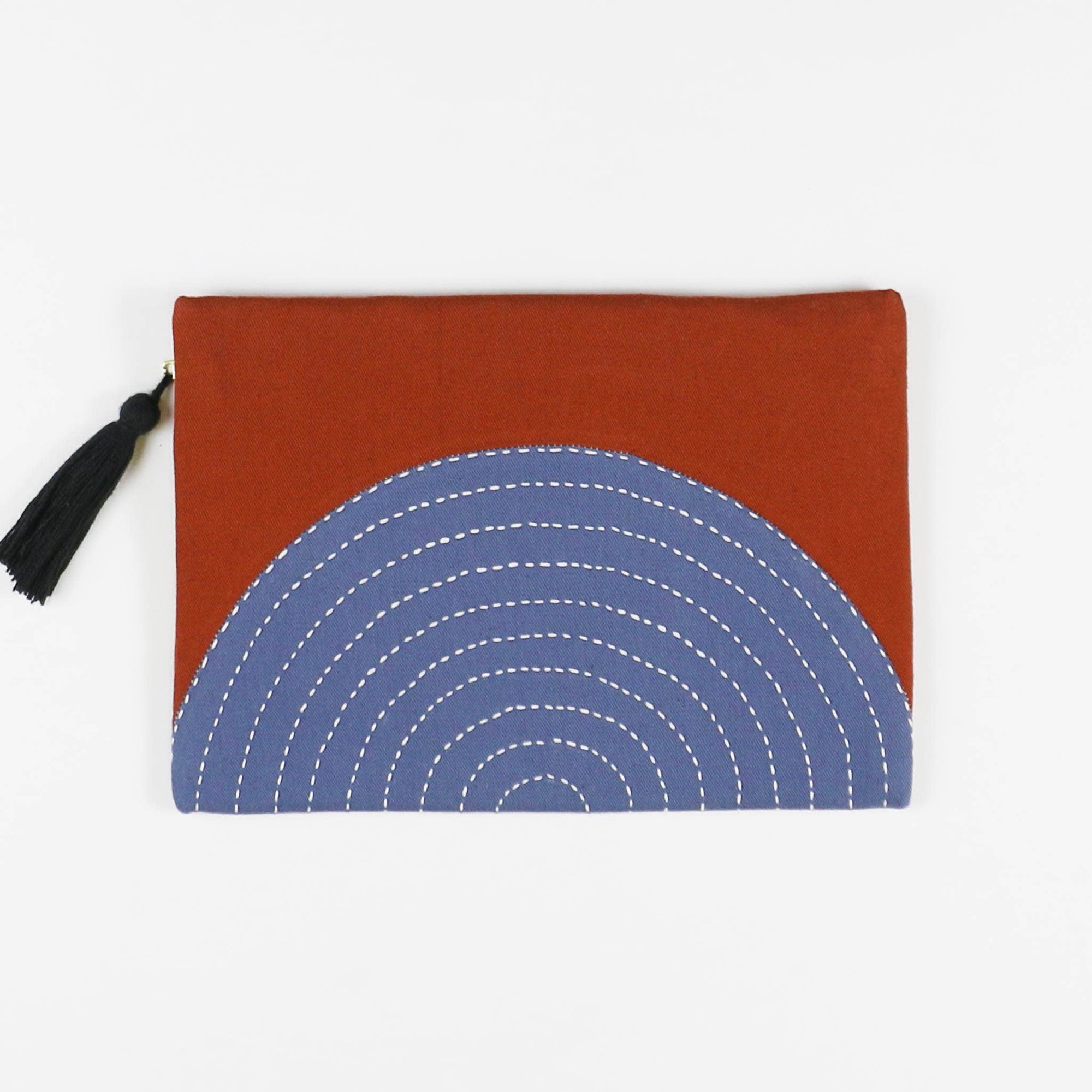 Pouch with blue circular pattern and rust-colored flap on a white background