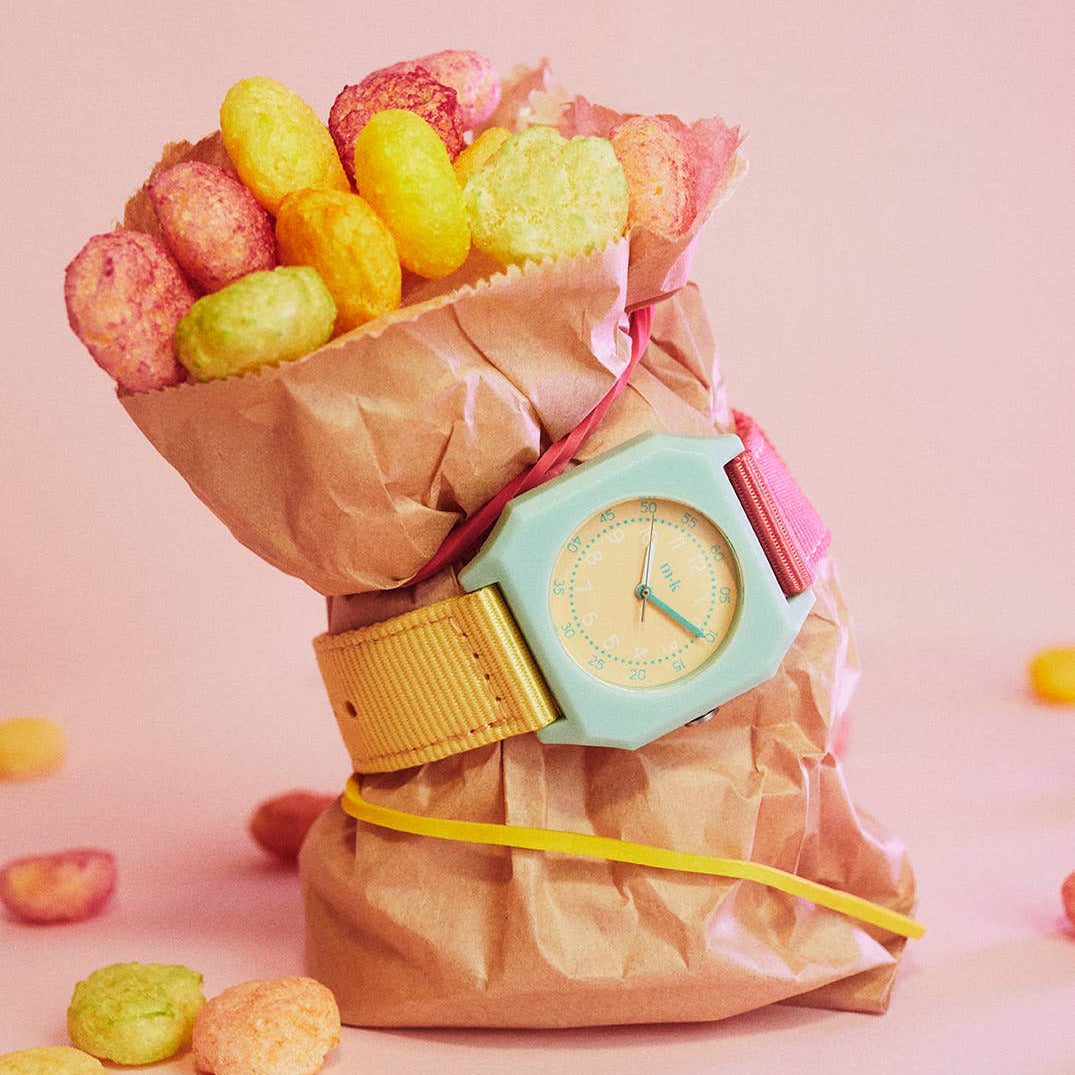 Colorful watch with a bouquet of jelly beans on a pink background