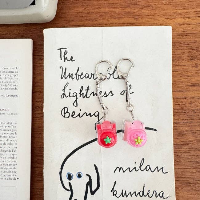 Pink keychain with small charms on a book page