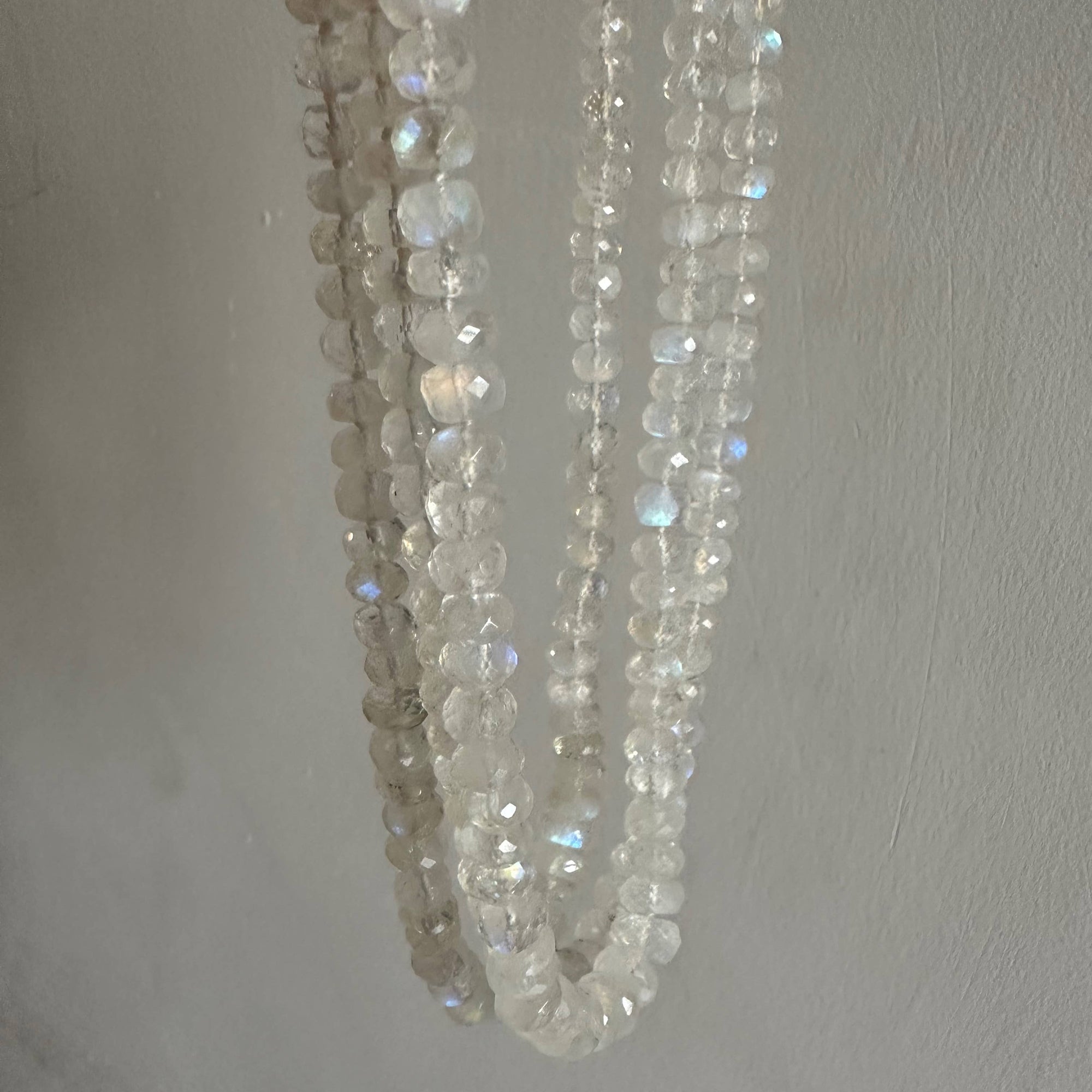 Close-up of a string of small, faceted beads against a plain background