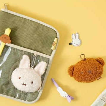 Set of small plush toys and stationery items on a yellow background