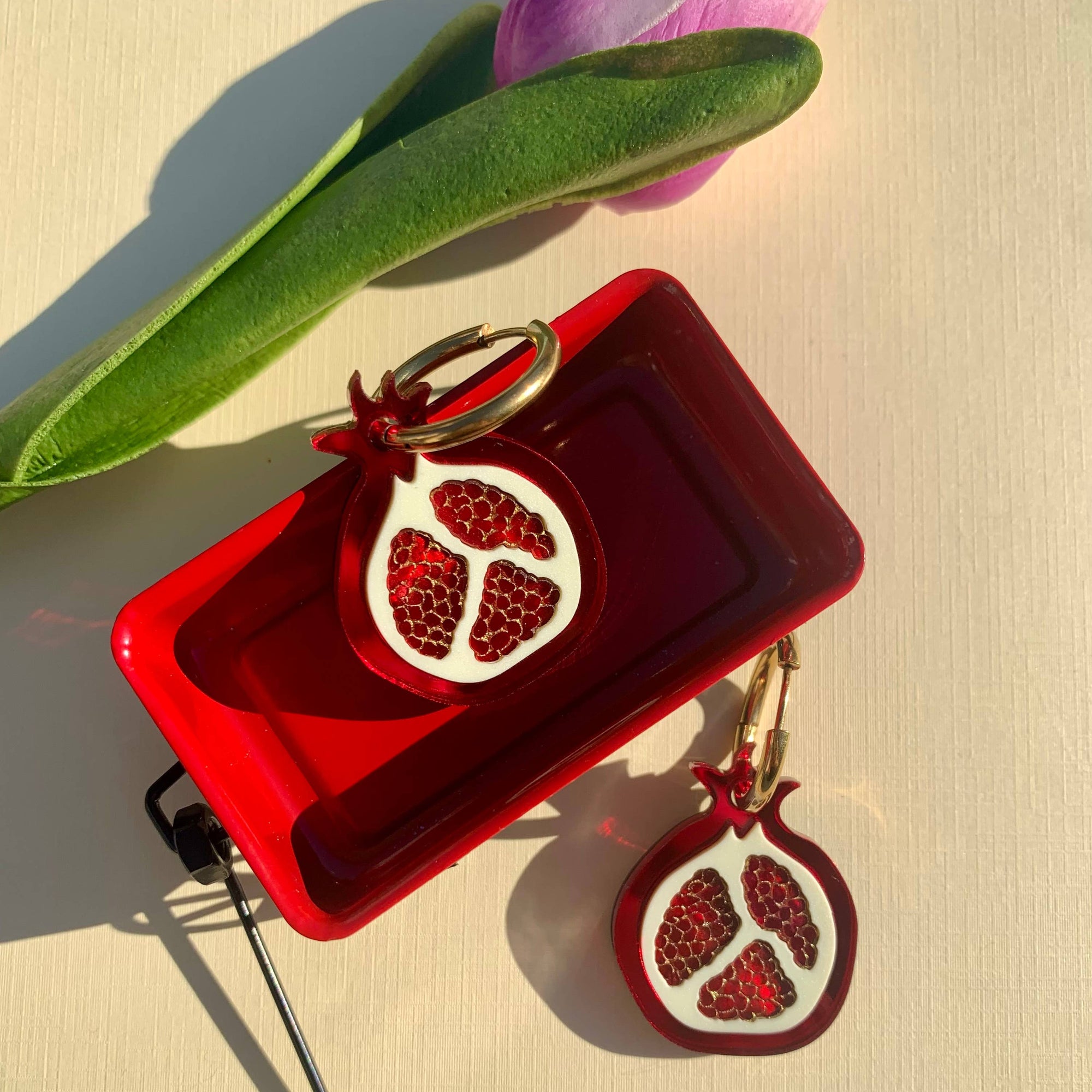 Red decorative box with pomegranate design on a beige surface