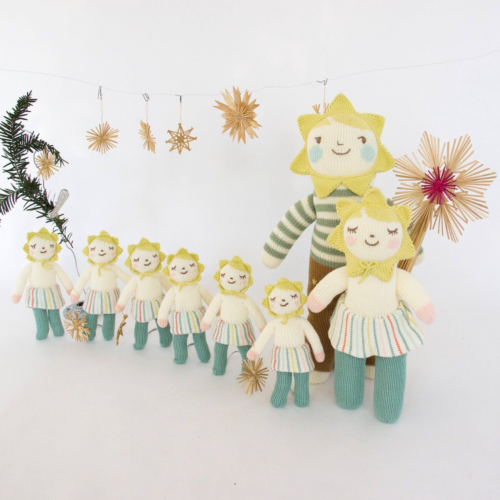 Set of plush toys resembling sun characters with decorative elements on a white background