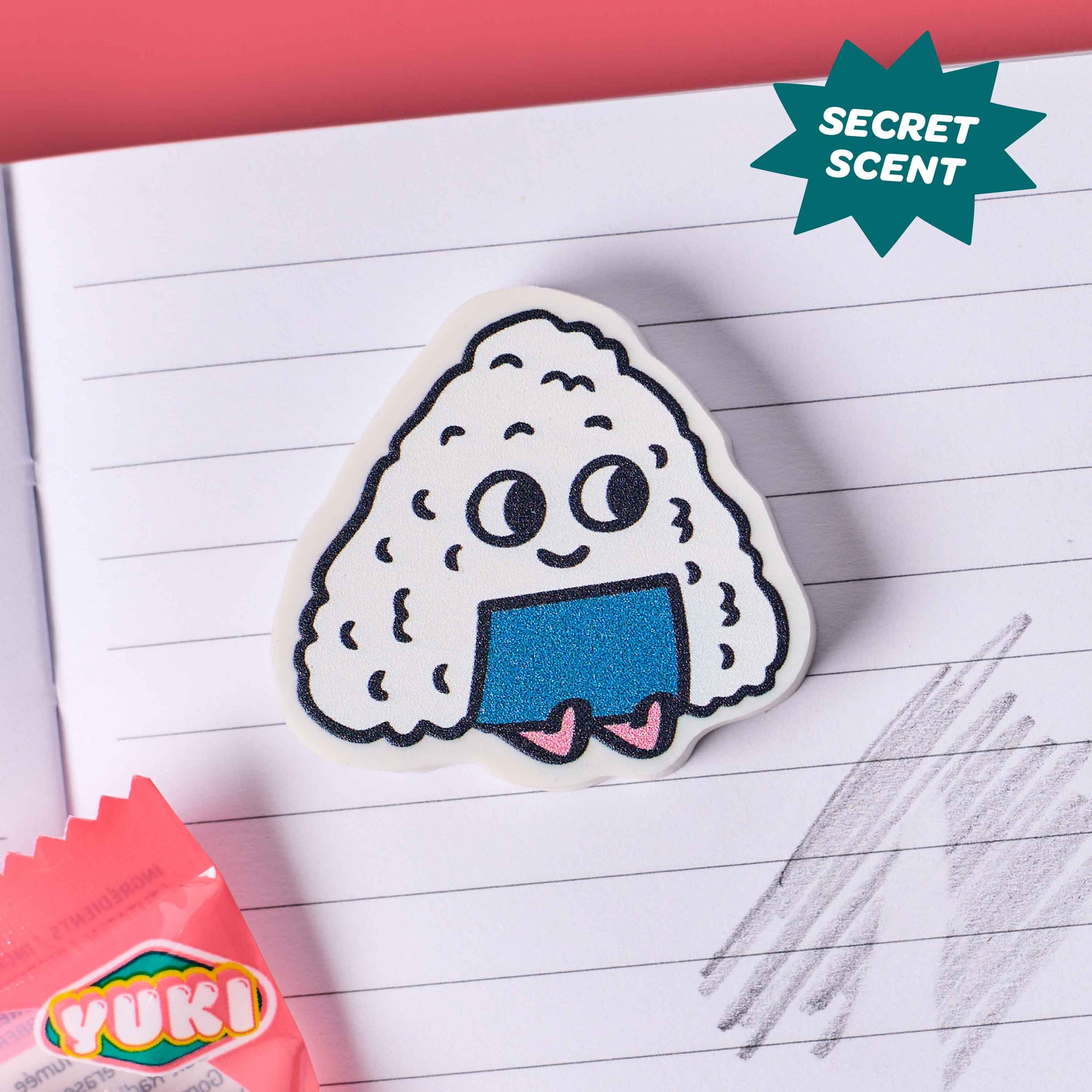 Cartoon rice ball with a blue interior on lined paper, next to a YUKI candy wrapper.