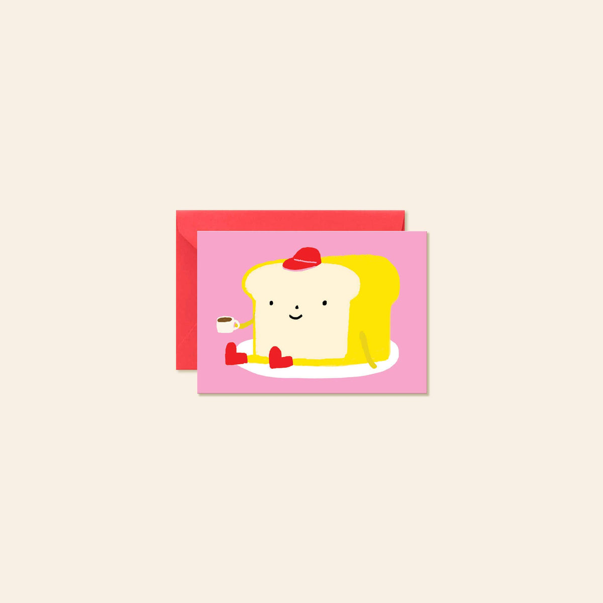 A greeting card featuring a cute cartoon illustration of a smiling slice of toast wearing a red hat and red shoes, sitting on a white plate against a pink background. A red envelope is placed behind the card on a light beige background.