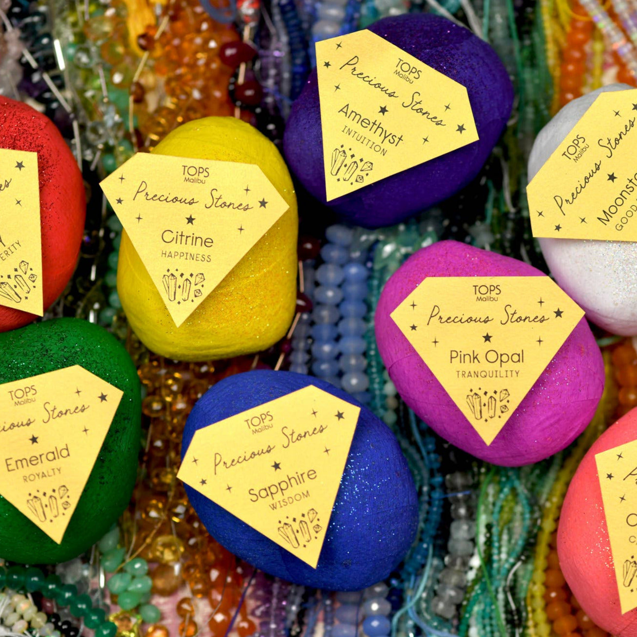 Colorful surprise balls with gemstones inside on labels against a textured background