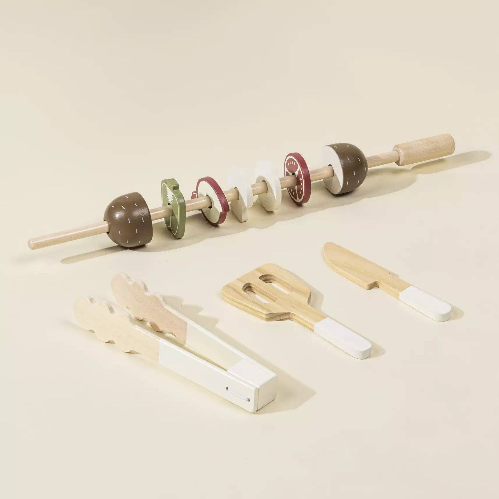 Set of wooden tools including a rolling pin, clothespins, and a small wooden block on a beige background.