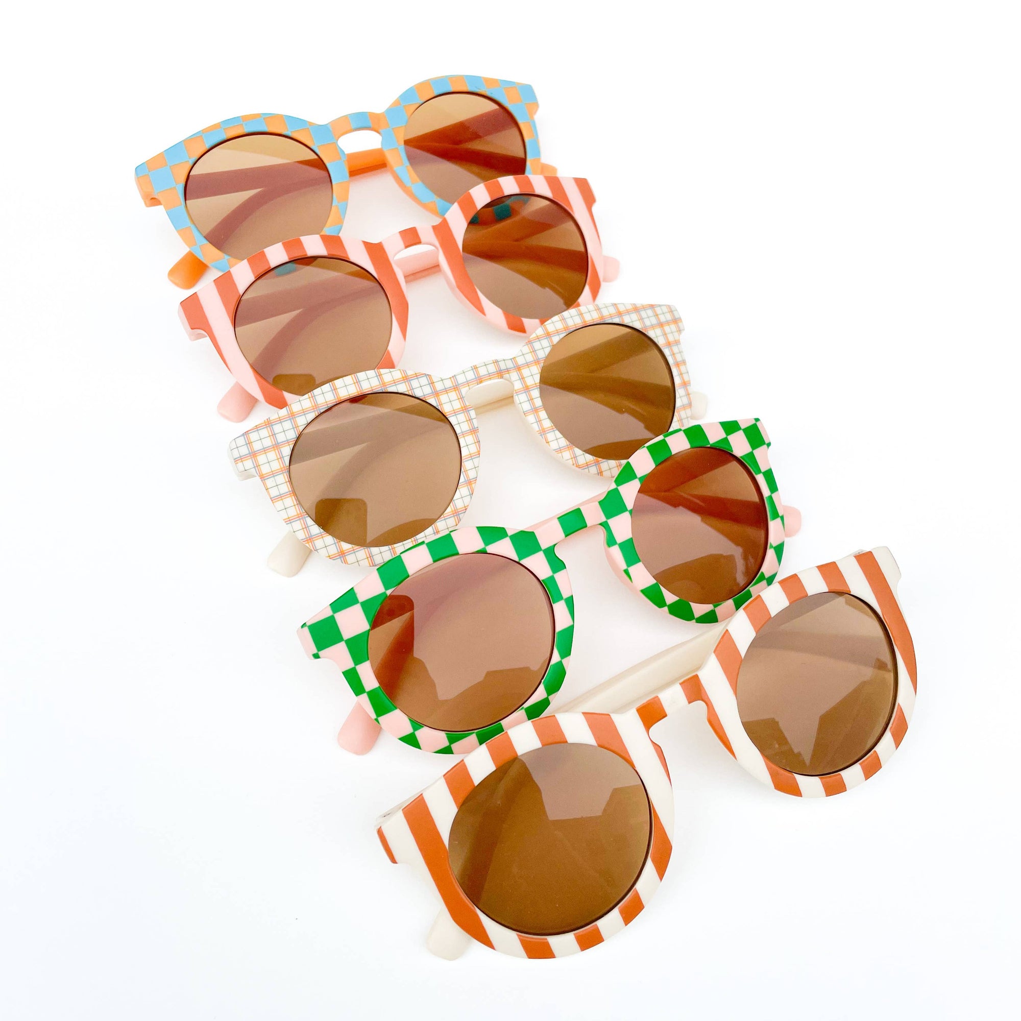 Stack of colorful sunglasses with decorative frames on a white background