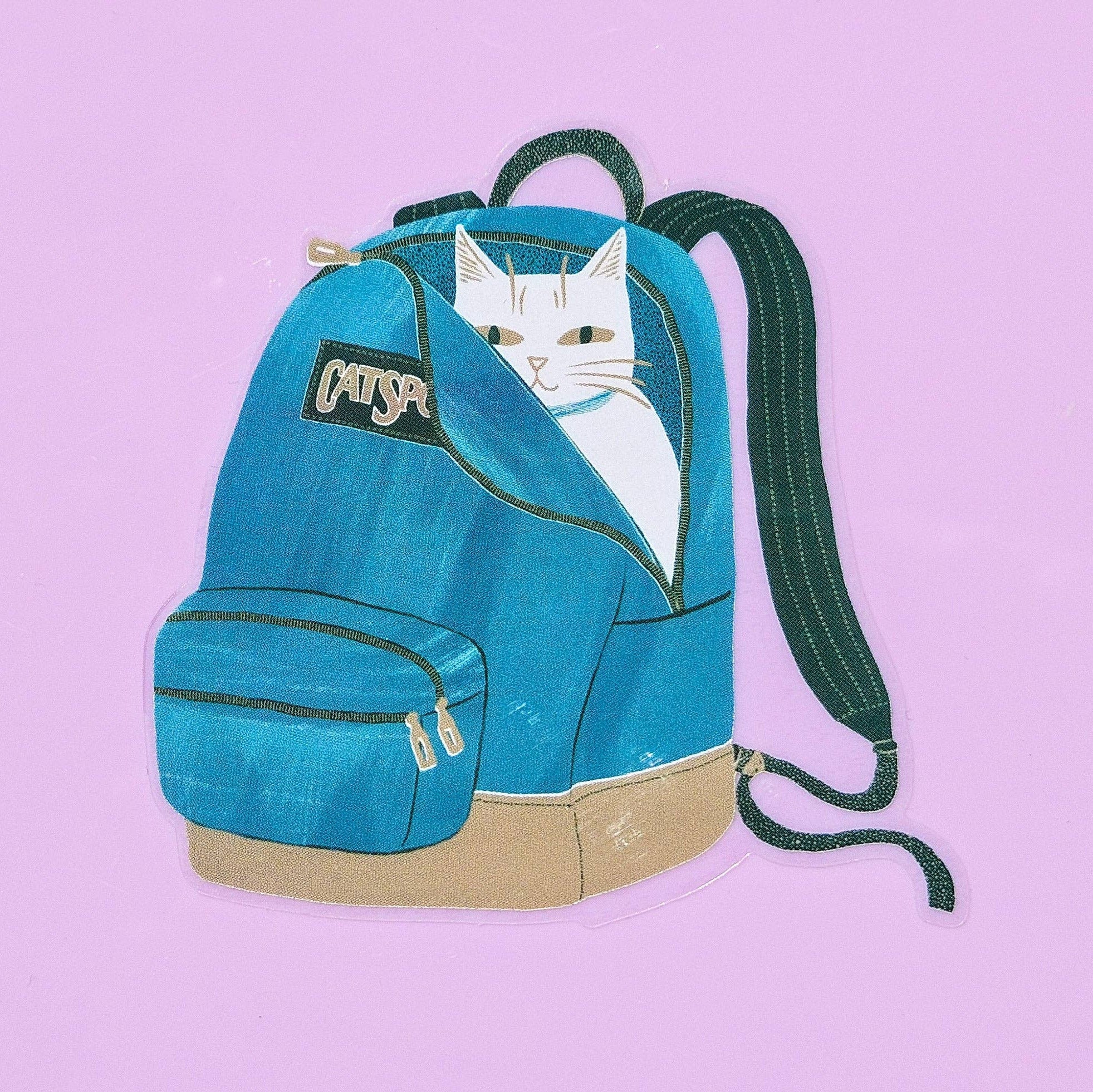 Blue backpack with a cat designed sticker on a pink background