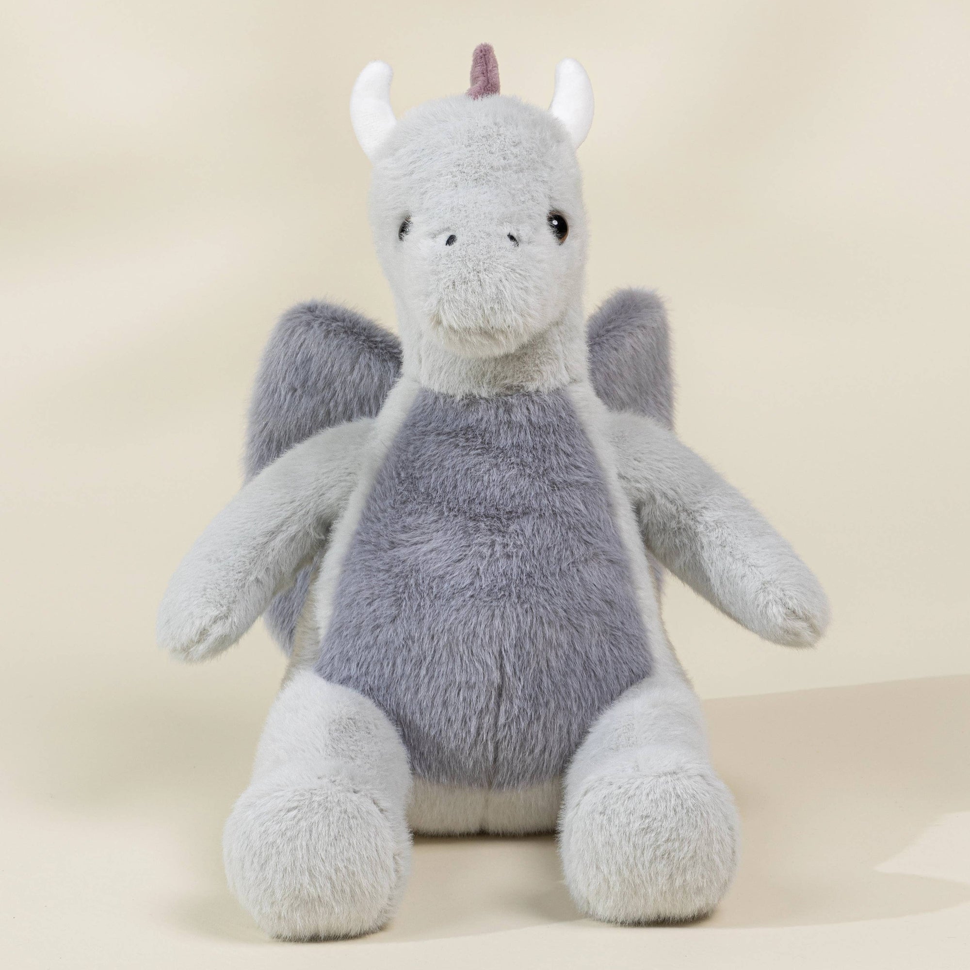 Plush dragon toy on a beige background