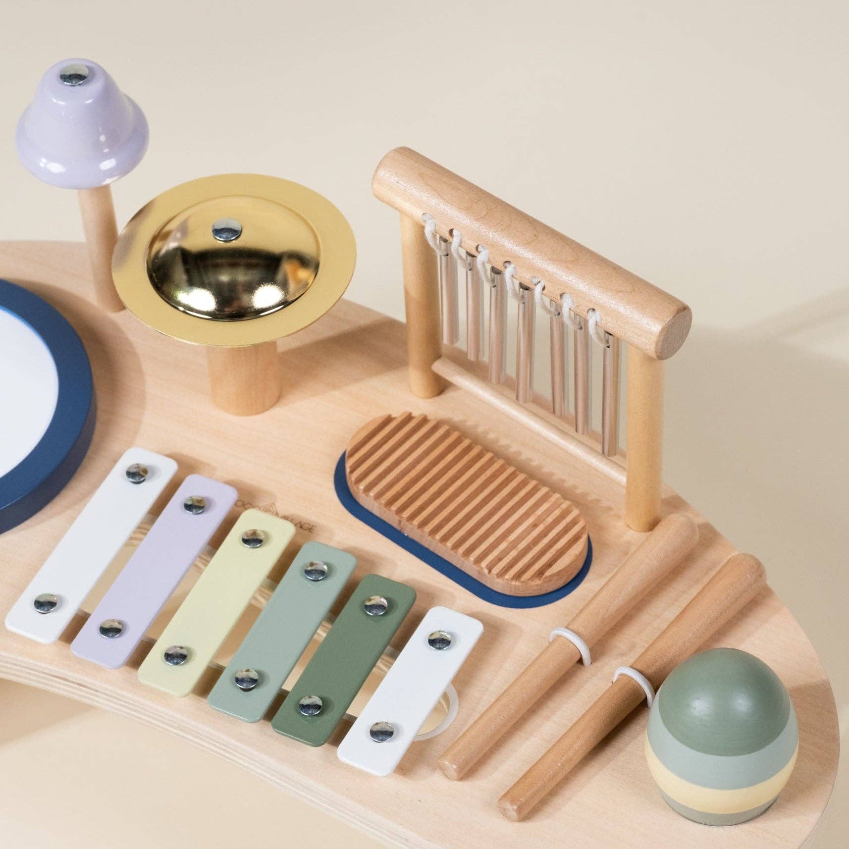 Wooden toy music set with various instruments on a beige background