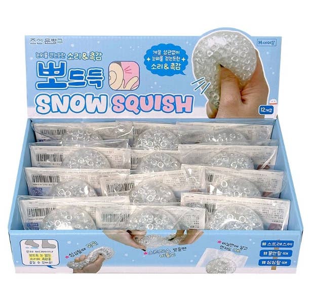 Display box of Snow Squish toys with packaging and product images.