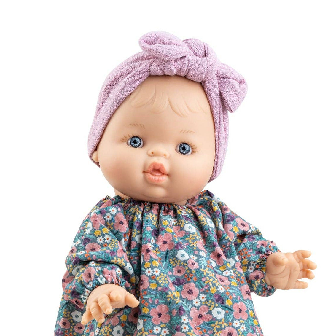 Baby doll with floral dress and pink headband on a white background