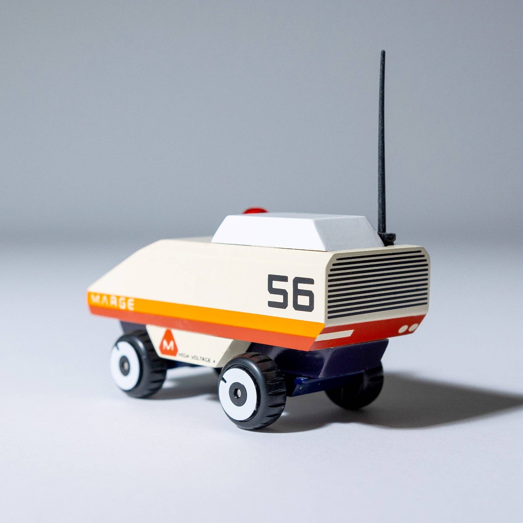 Toy robot with a white body, orange stripe, and black antenna on a gray background