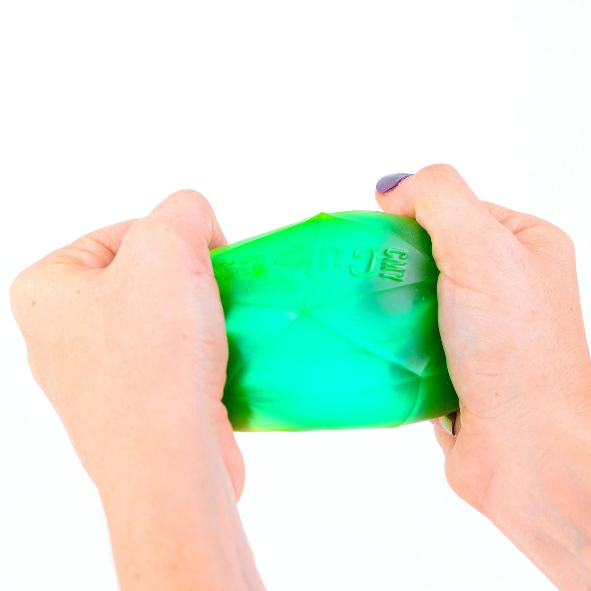 Green stress ball being held and squeezed by hands on a white background