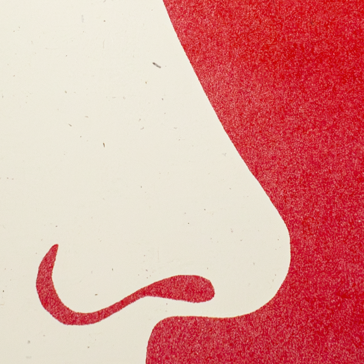 A close-up abstract graphic print featuring a stylized side profile of a face in red on an off-white background, with a textured, grainy finish.