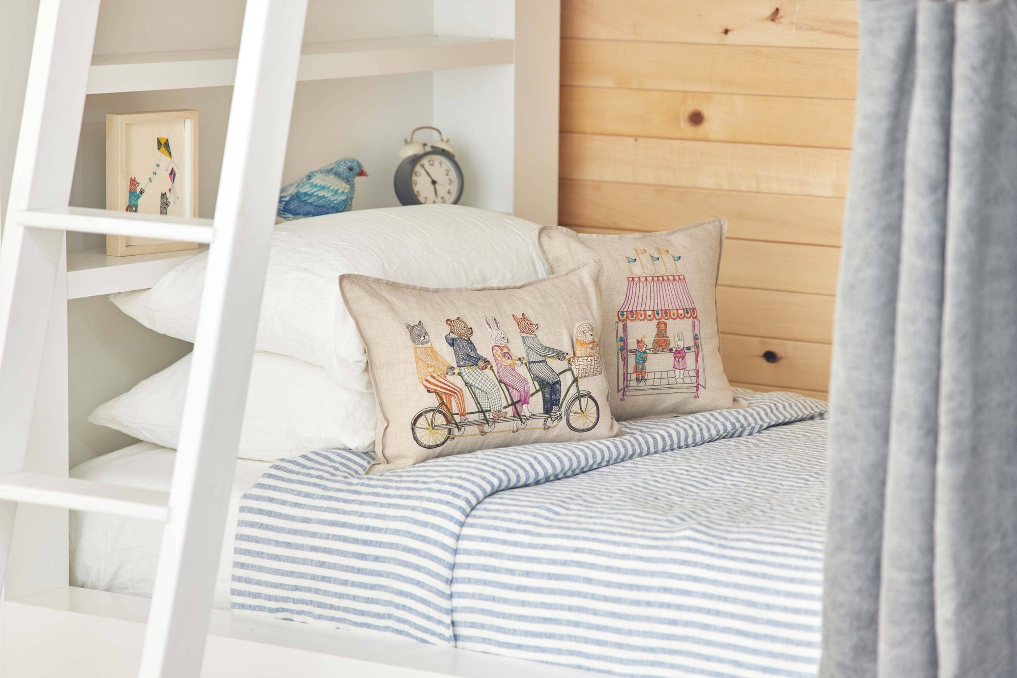 Children's bedroom with a bed, pillows, and a bookshelf.