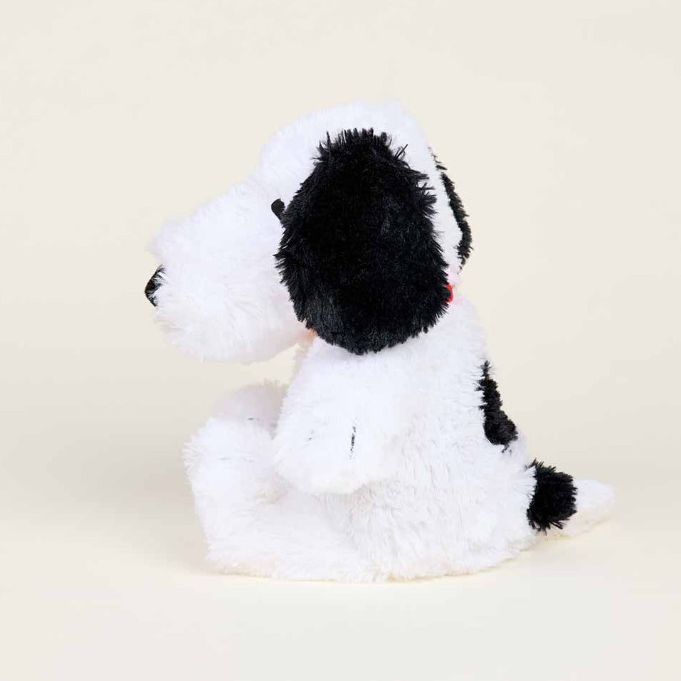 Plush dog toy with black and white fur on a beige background