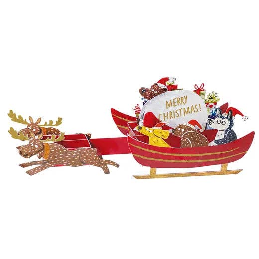 Red sleigh with reindeer, Christmas-themed decorations, and 'Merry Christmas!' sign on a white background.