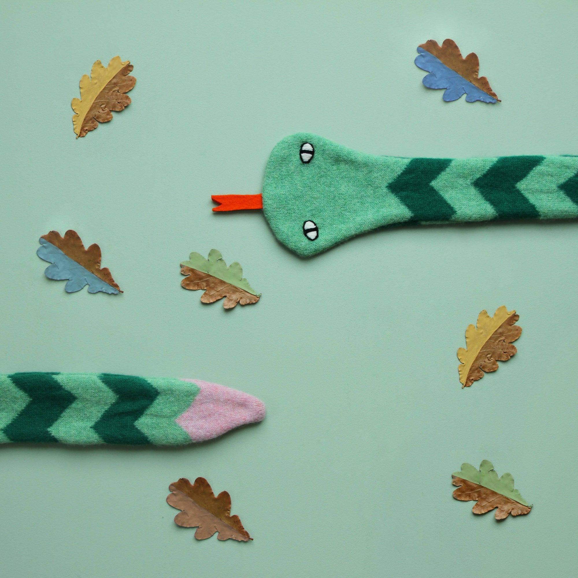 Scarf snake with chevron pattern on a light green background