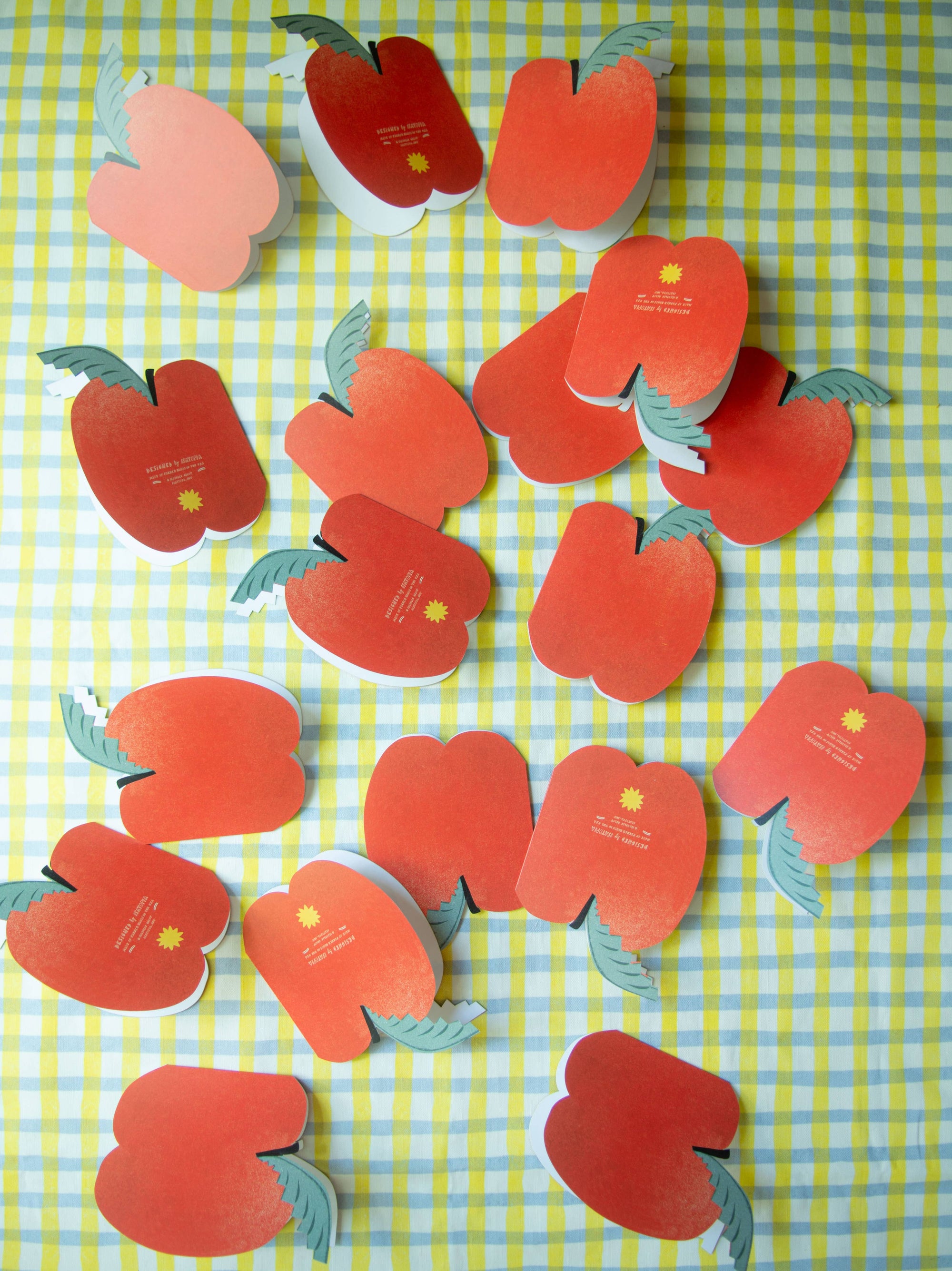 Red apple-shaped cards on a green and yellow checkered background