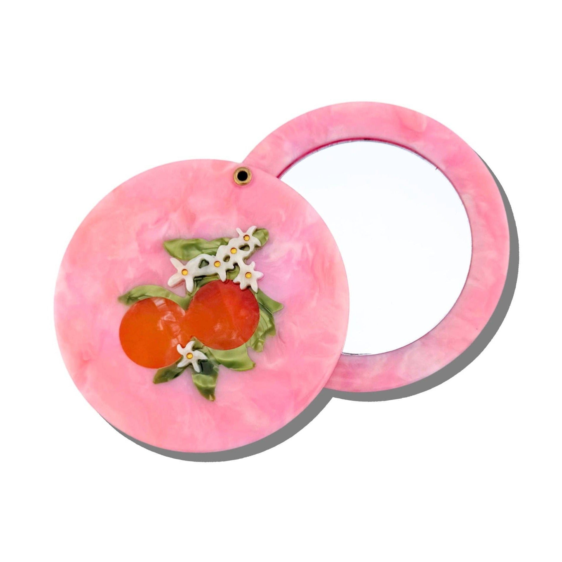Pink compact mirror with floral design on a white background