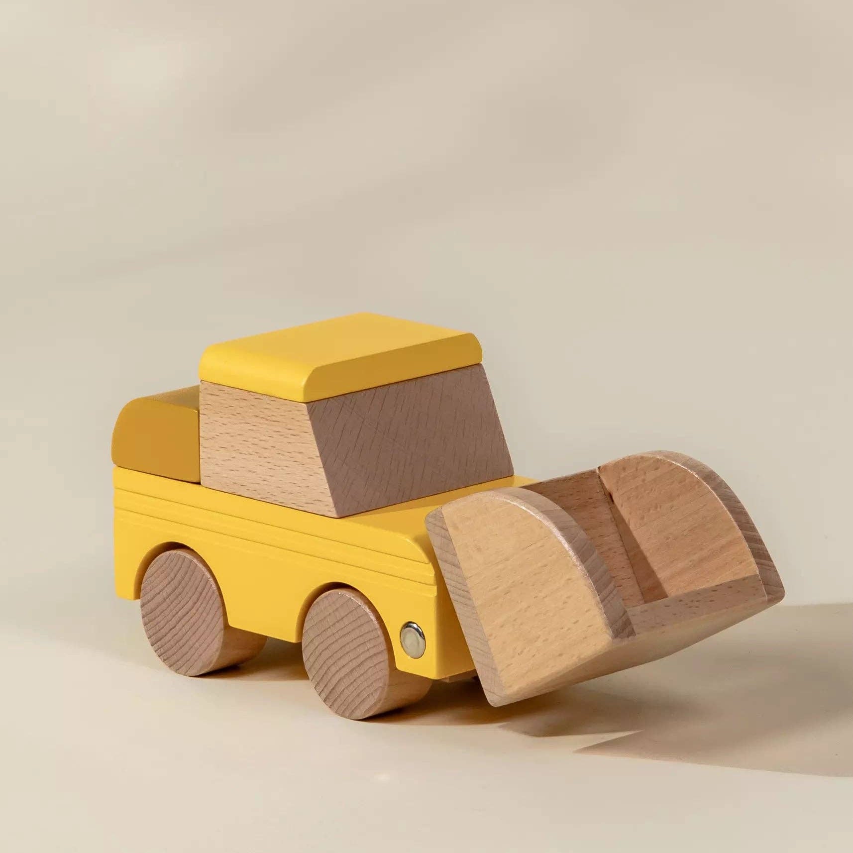 Wooden toy bulldozer with yellow body and brown front on a beige background