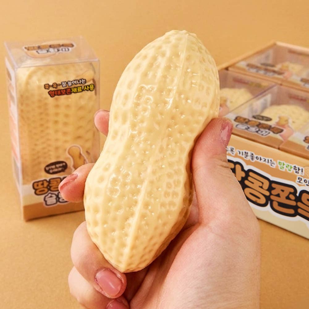 Hand holding a large yellow sponge with packaging in the background