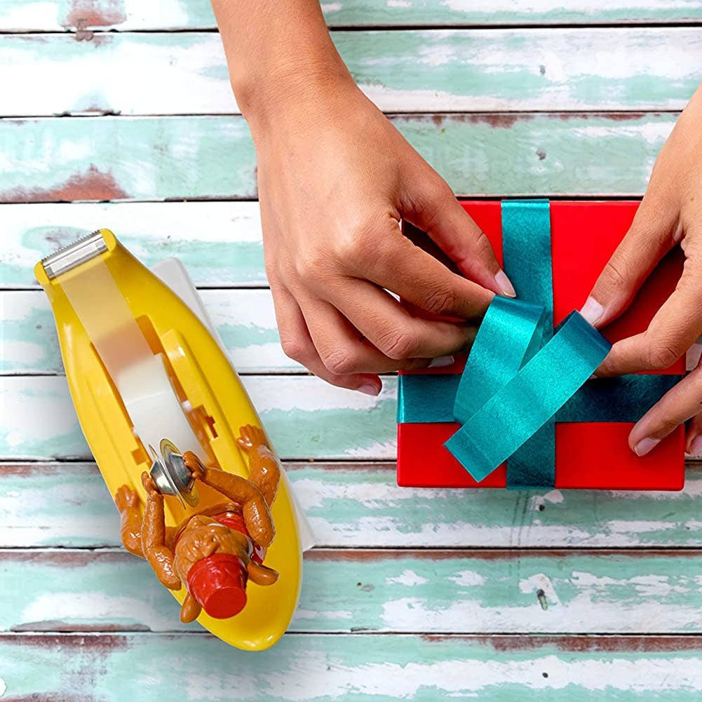 Person wrapping a gift with blue ribbon on a wooden surface