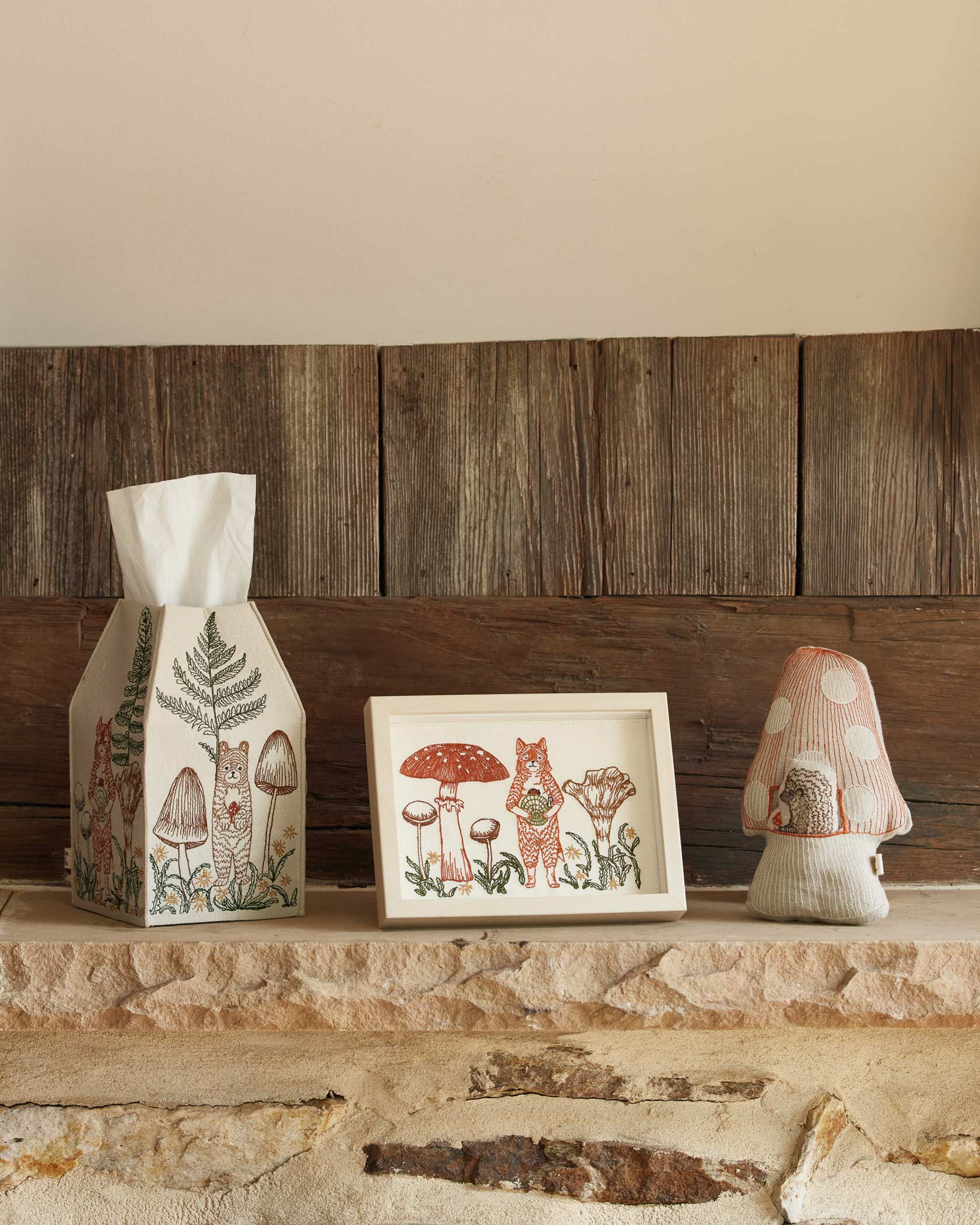 Decorative items including a tissue box, framed picture, and small lamp on a stone surface with wooden paneling in the background.