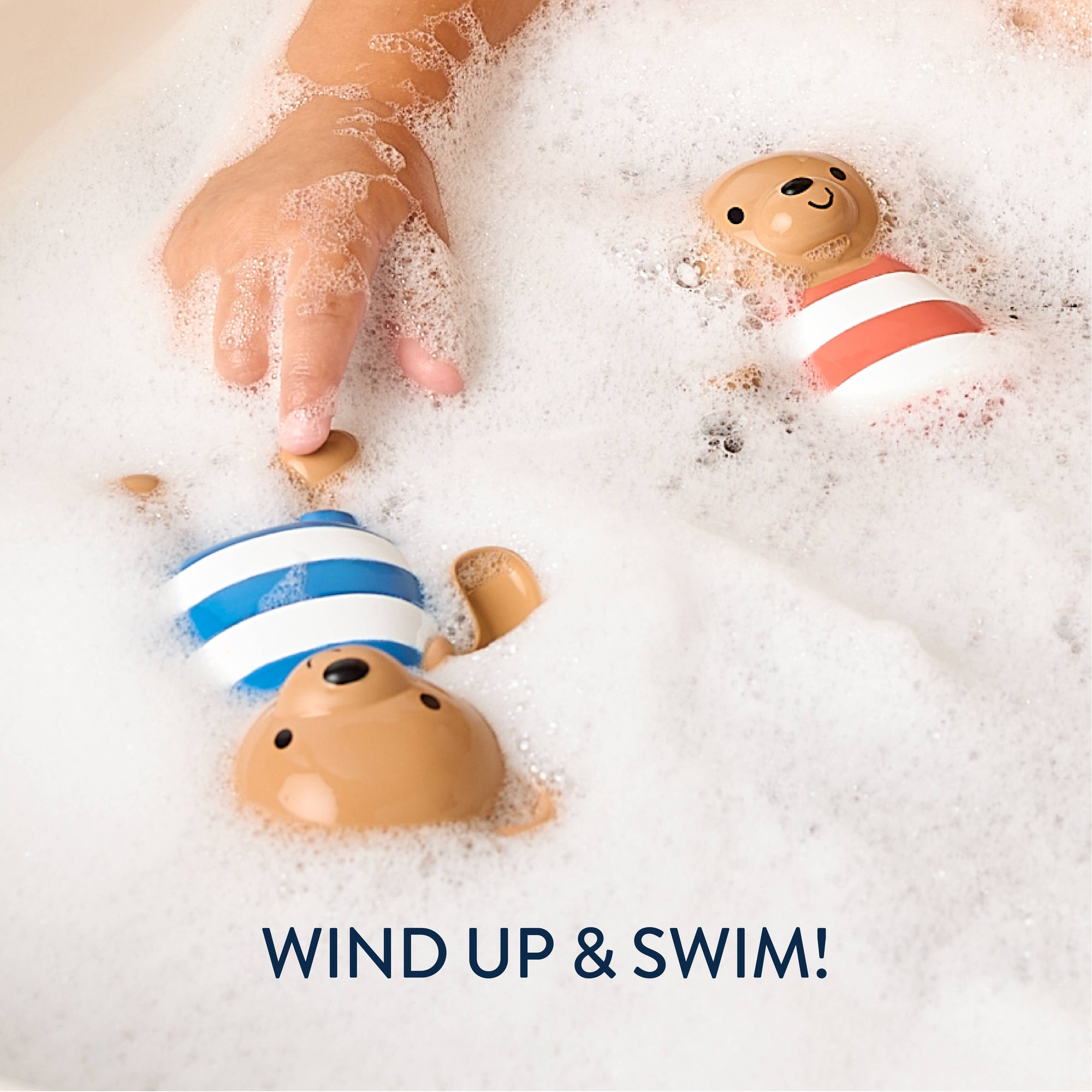 Two toy ducks in a bathtub with bubbles and a child's hand, with text 'Wind Up & Swim!'.