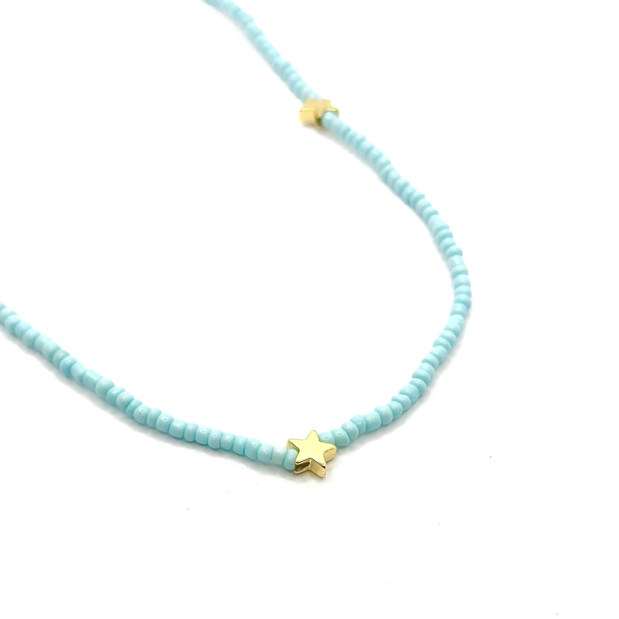 Turquoise beaded necklace with gold star pendants on a white background