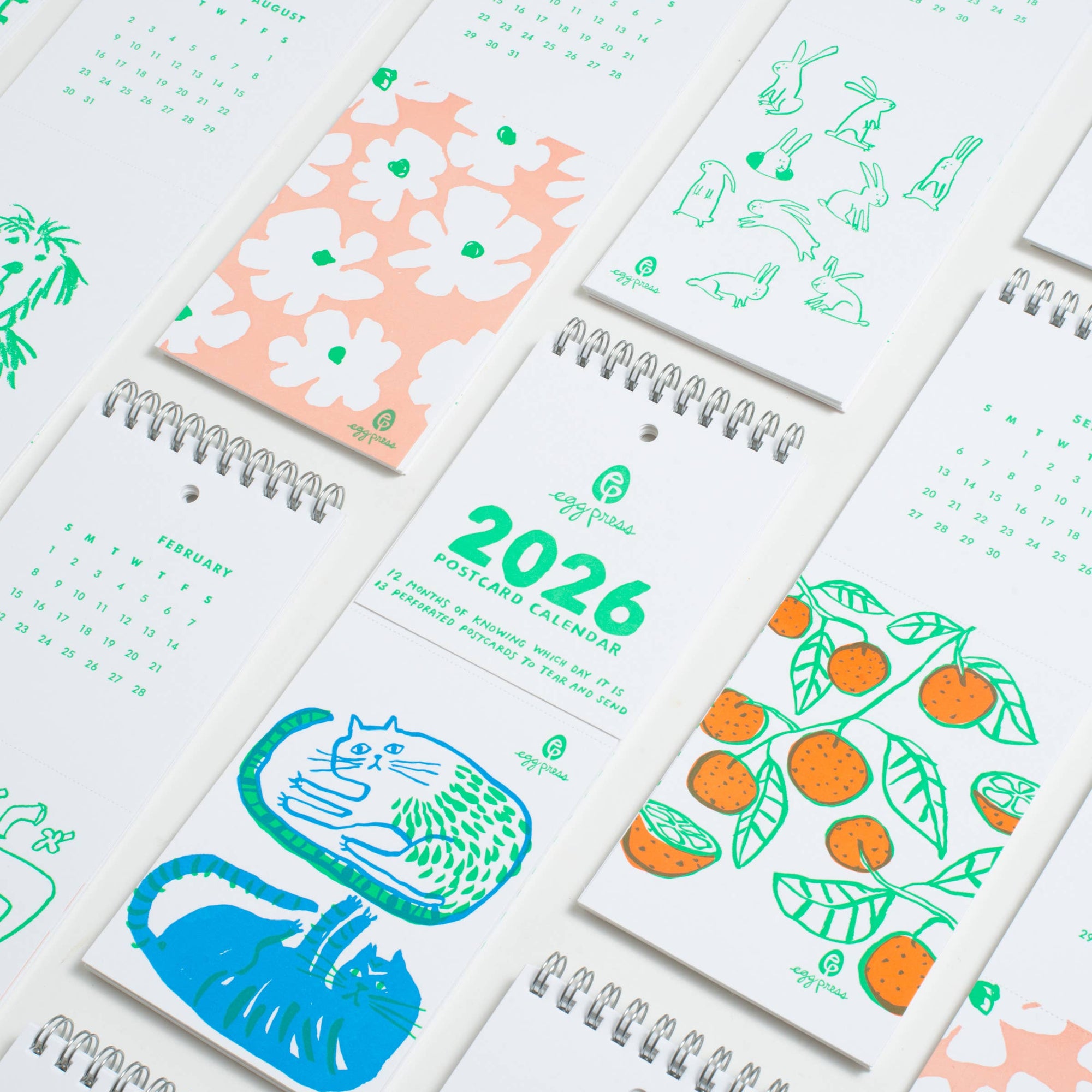 Collection of small spiral-bound calendars with colorful designs and '2026' text.