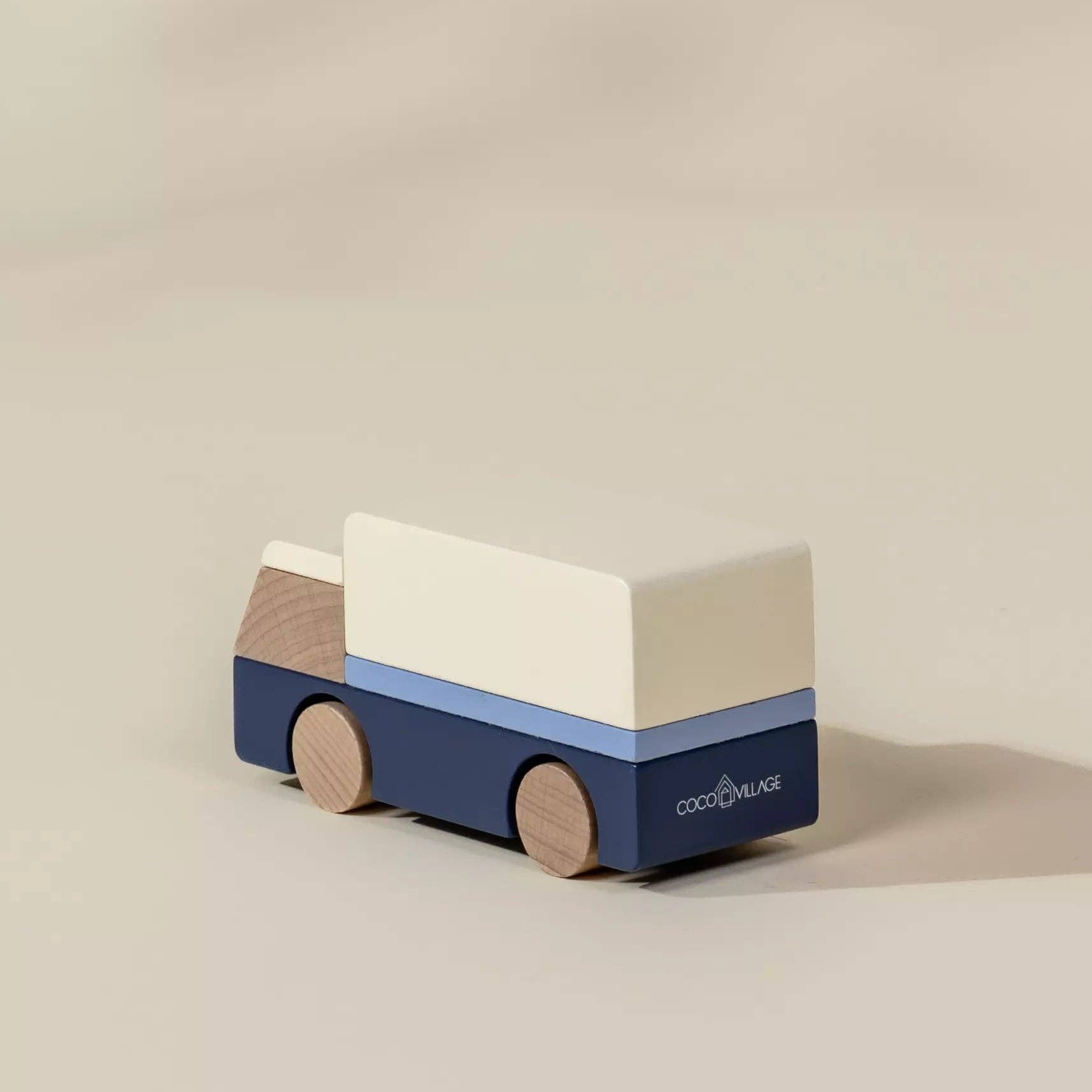 Wooden toy van with a blue body and beige roof on a beige background