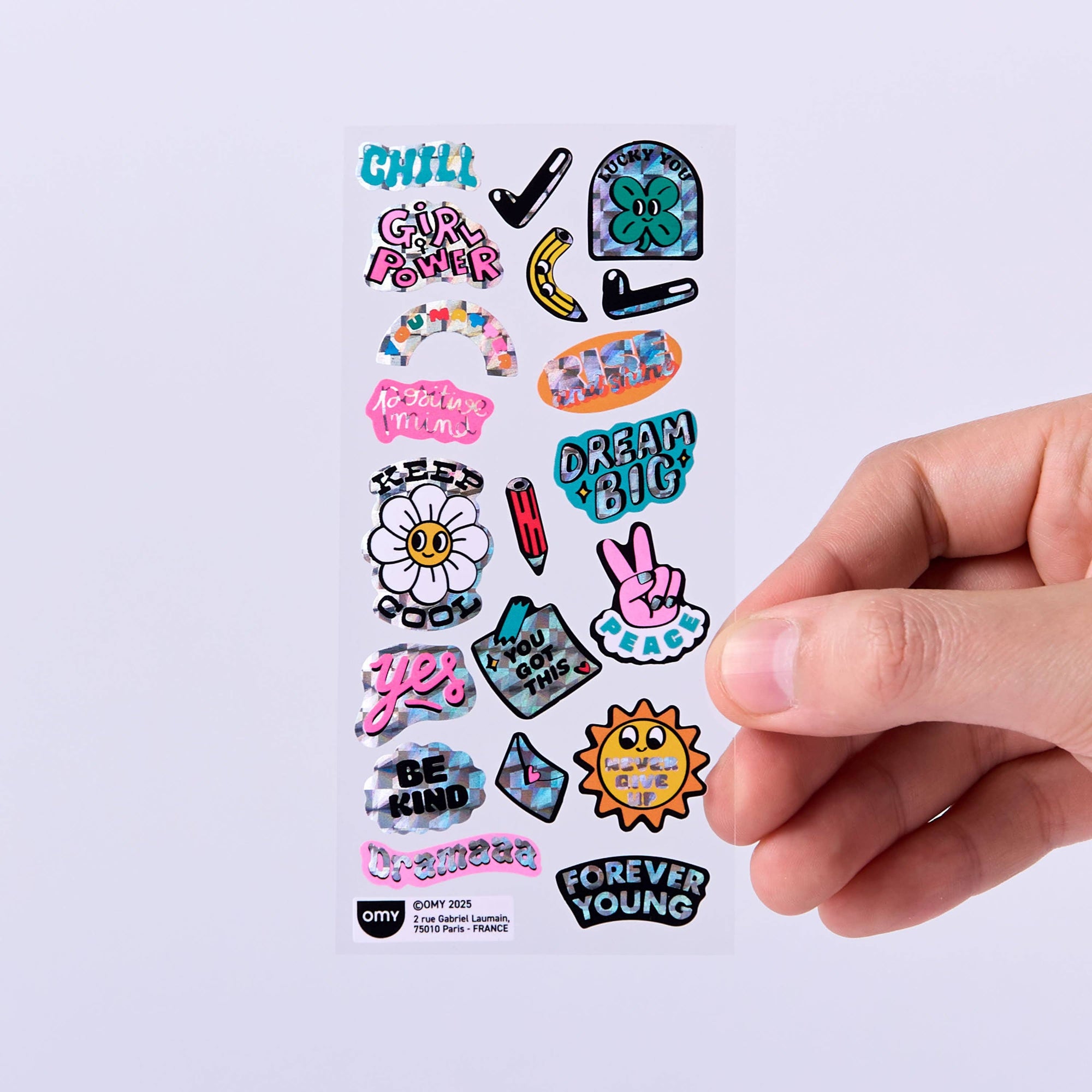 Collection of colorful stickers with various designs and text on a white background, held by a hand.