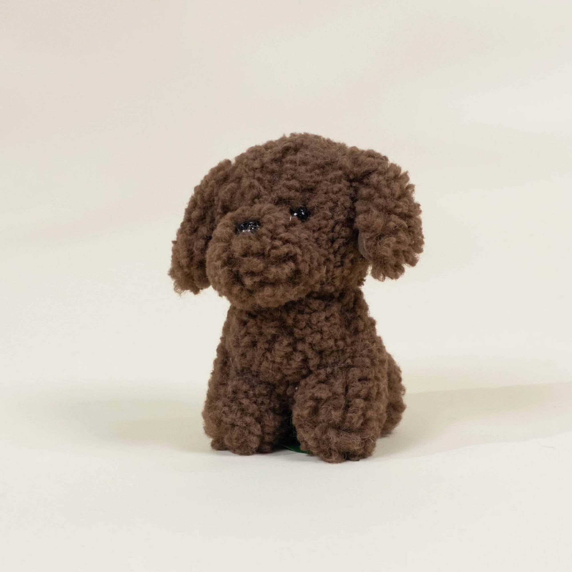 Brown plush dog toy on a beige background