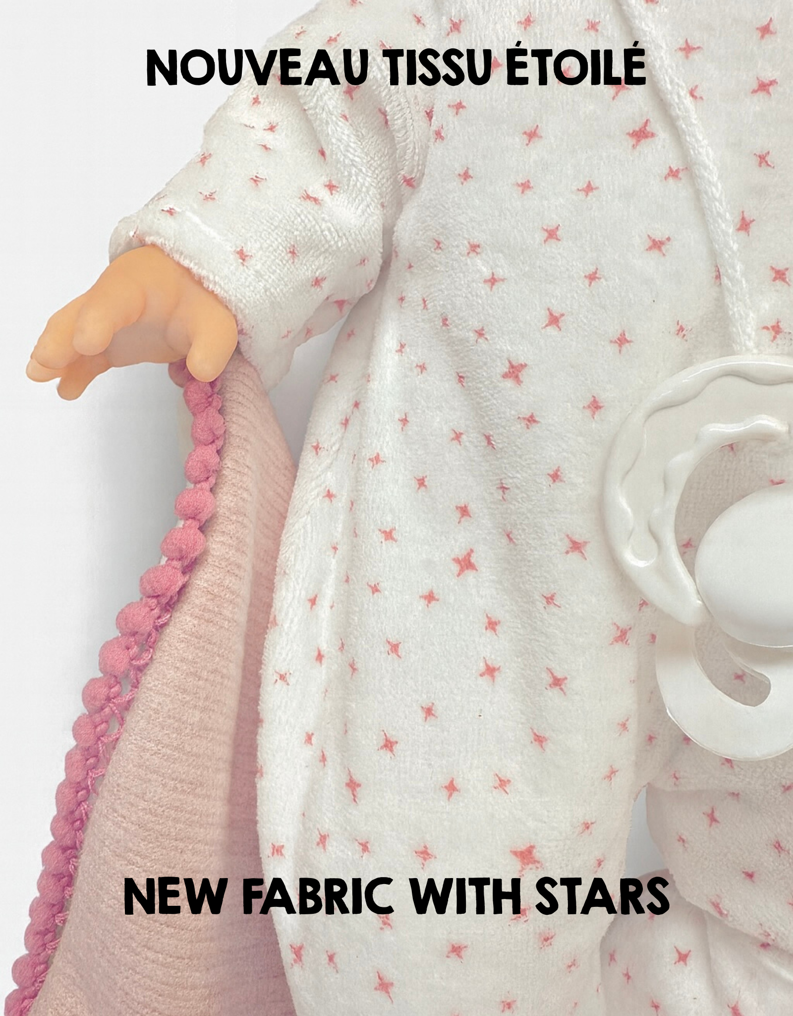 Close-up of a doll wearing a white outfit with pink star pattern and pink trim, with text indicating new fabric with stars.
