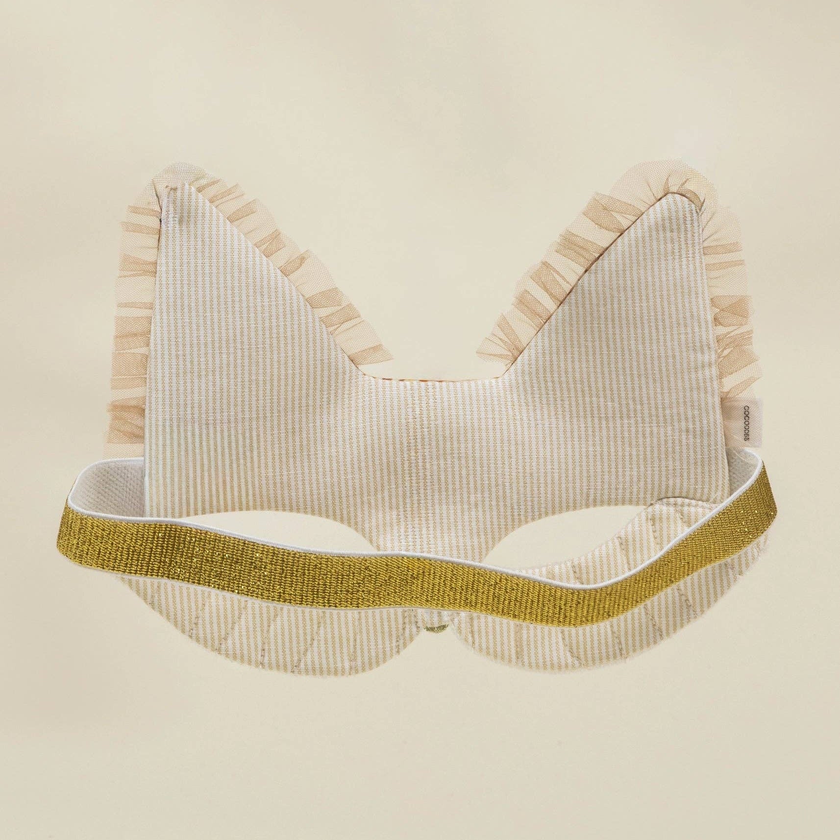 mask with gold band on a beige background