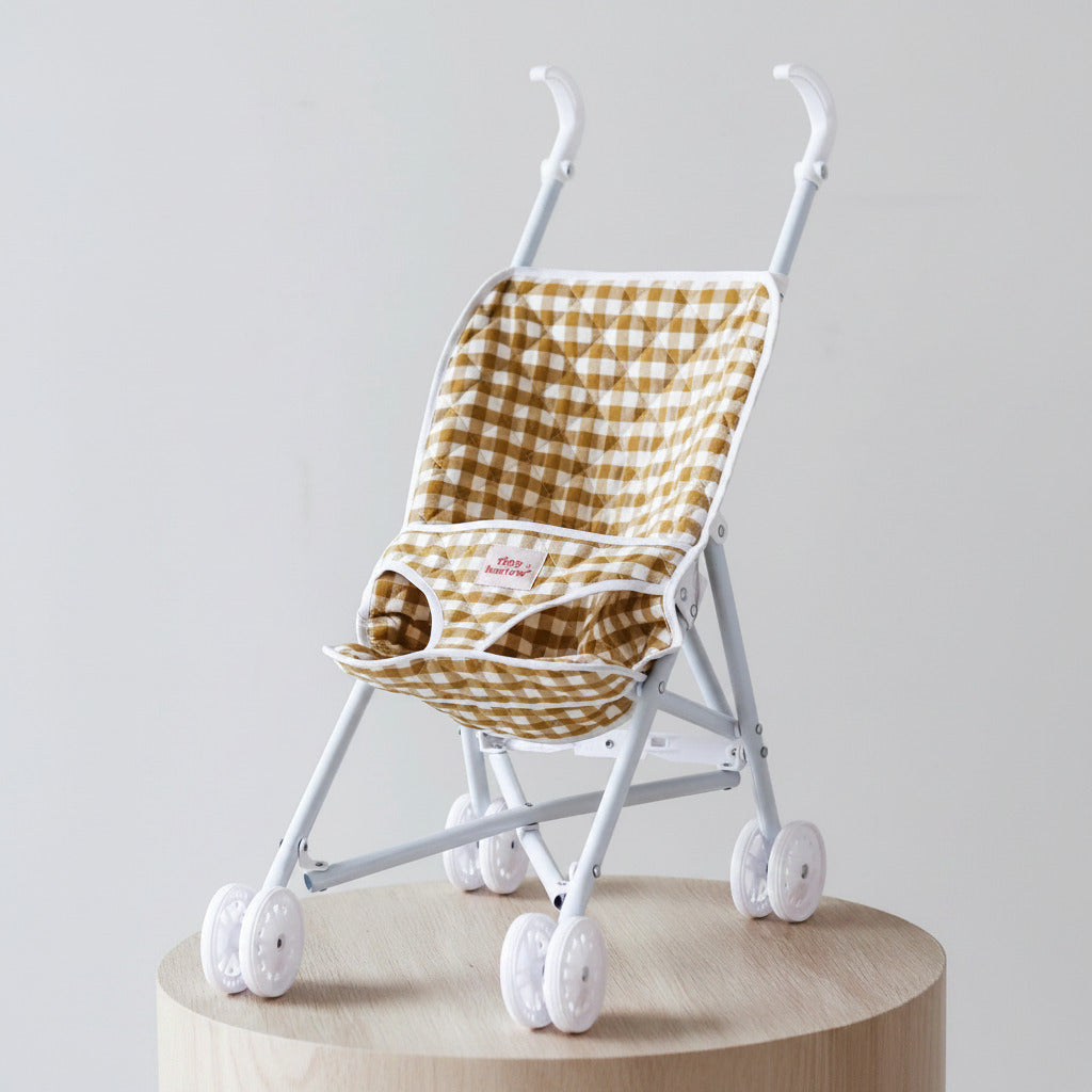 Small child's stroller with a yellow and white checkered seat on a light gray background
