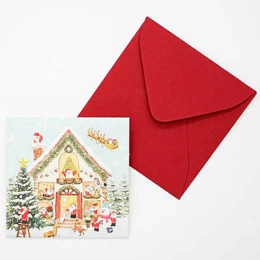 Christmas-themed card with gingerbread house design and a red envelope on a white background