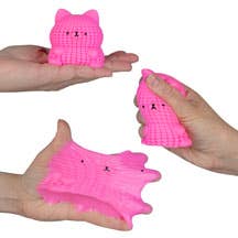 Pink silicone cat-shaped product held by hands against a neutral background