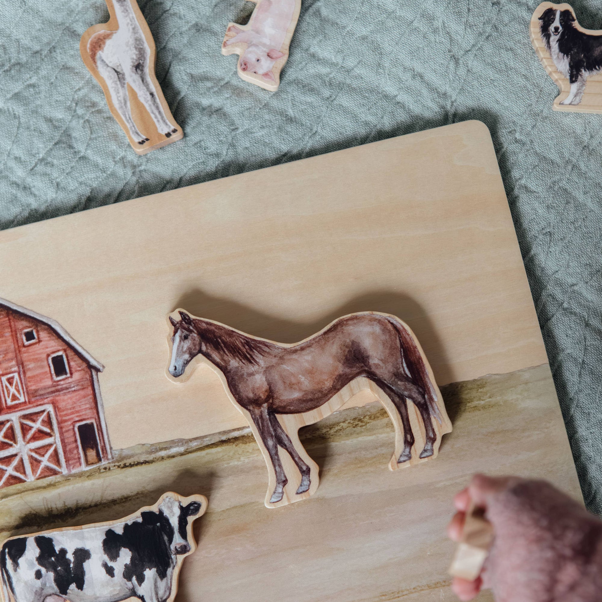 Wooden puzzle with animal shapes on a wooden board, including a horse, cow, and barn.