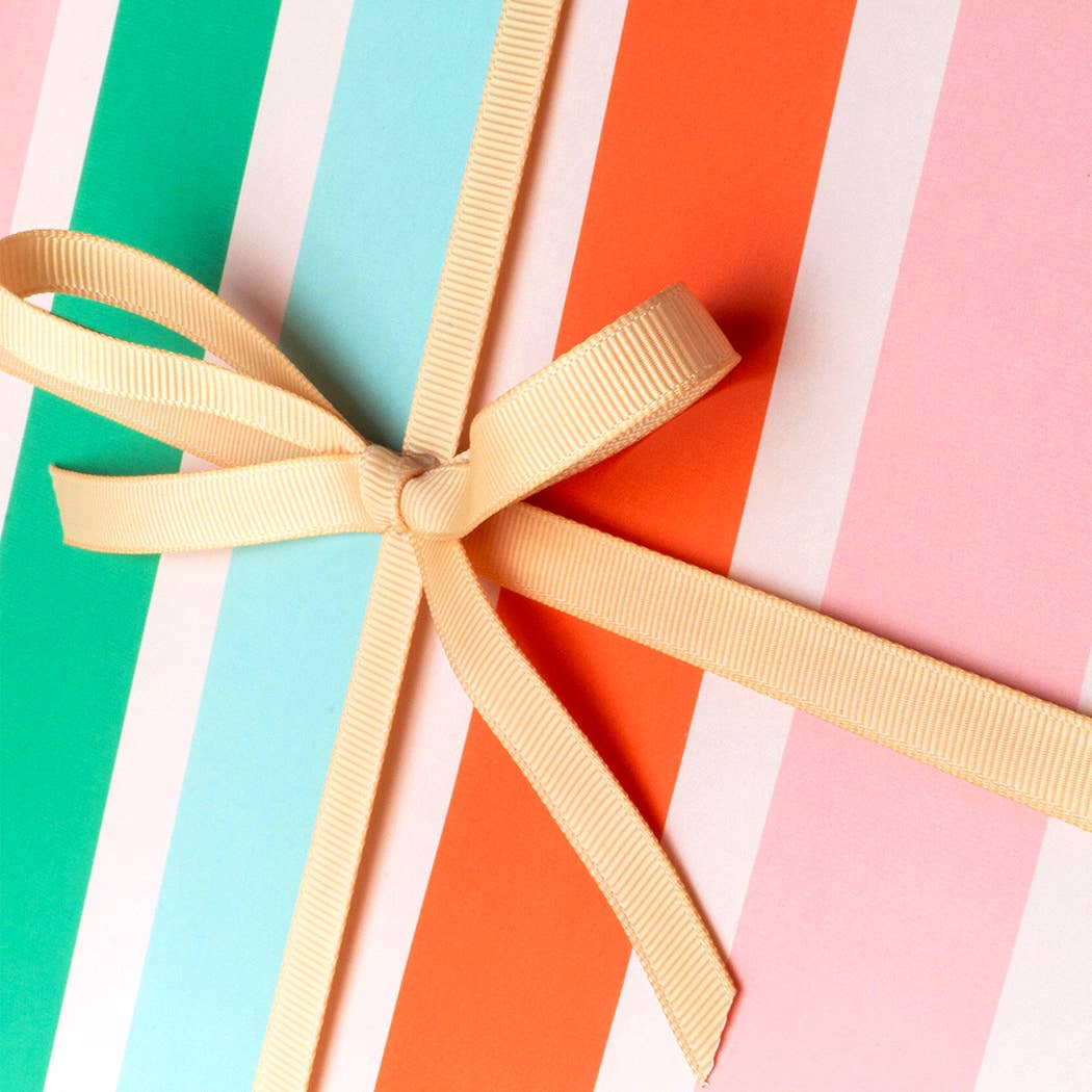 Gift box with a yellow ribbon on a colorful striped background
