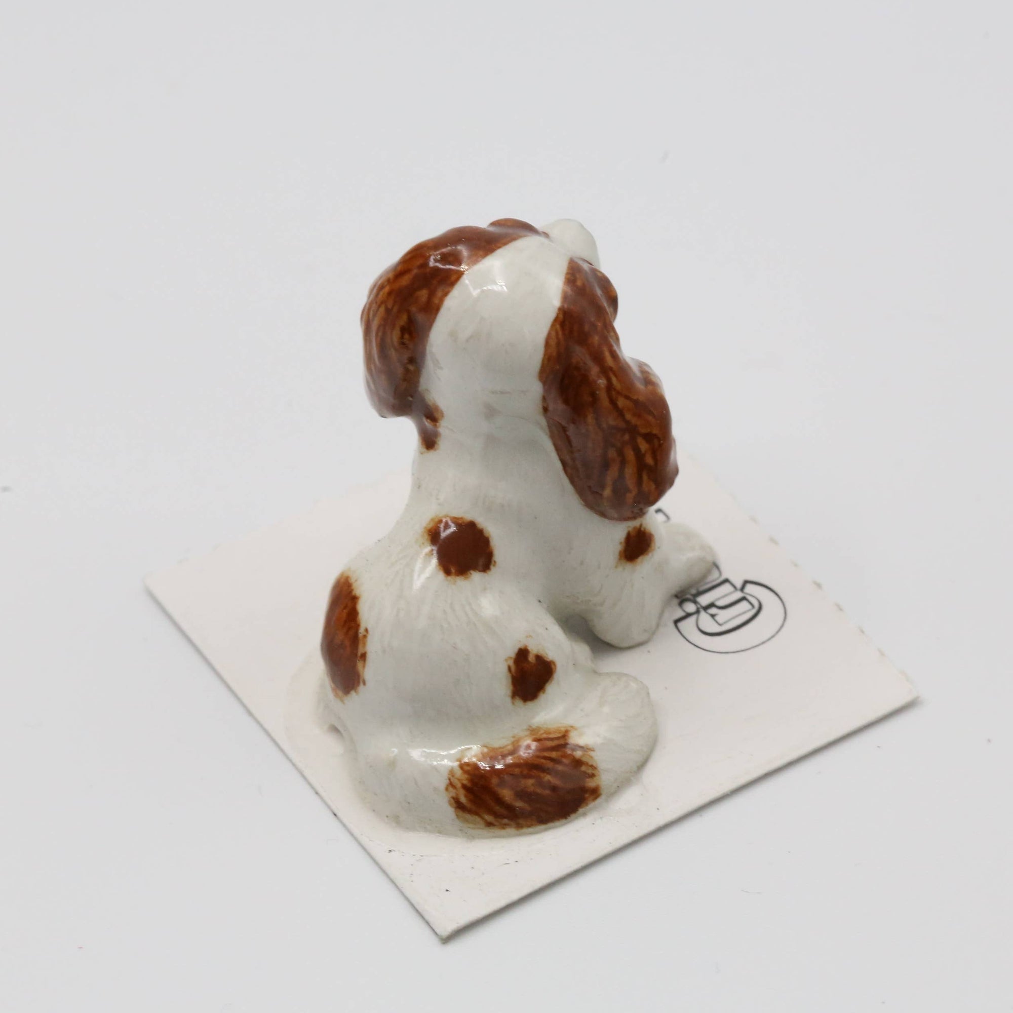Small ceramic dog figurine on a white background